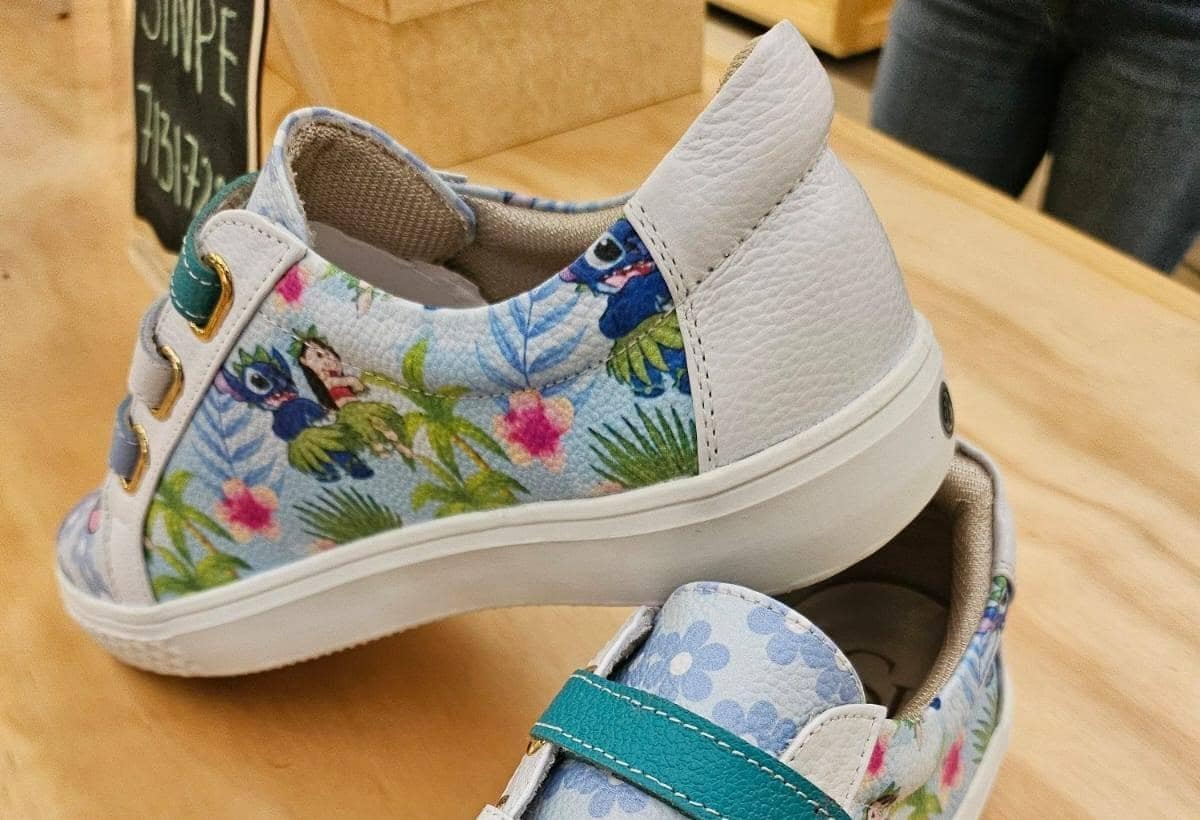Sneaker de estampado tropical verde agua sobre mesa de madera