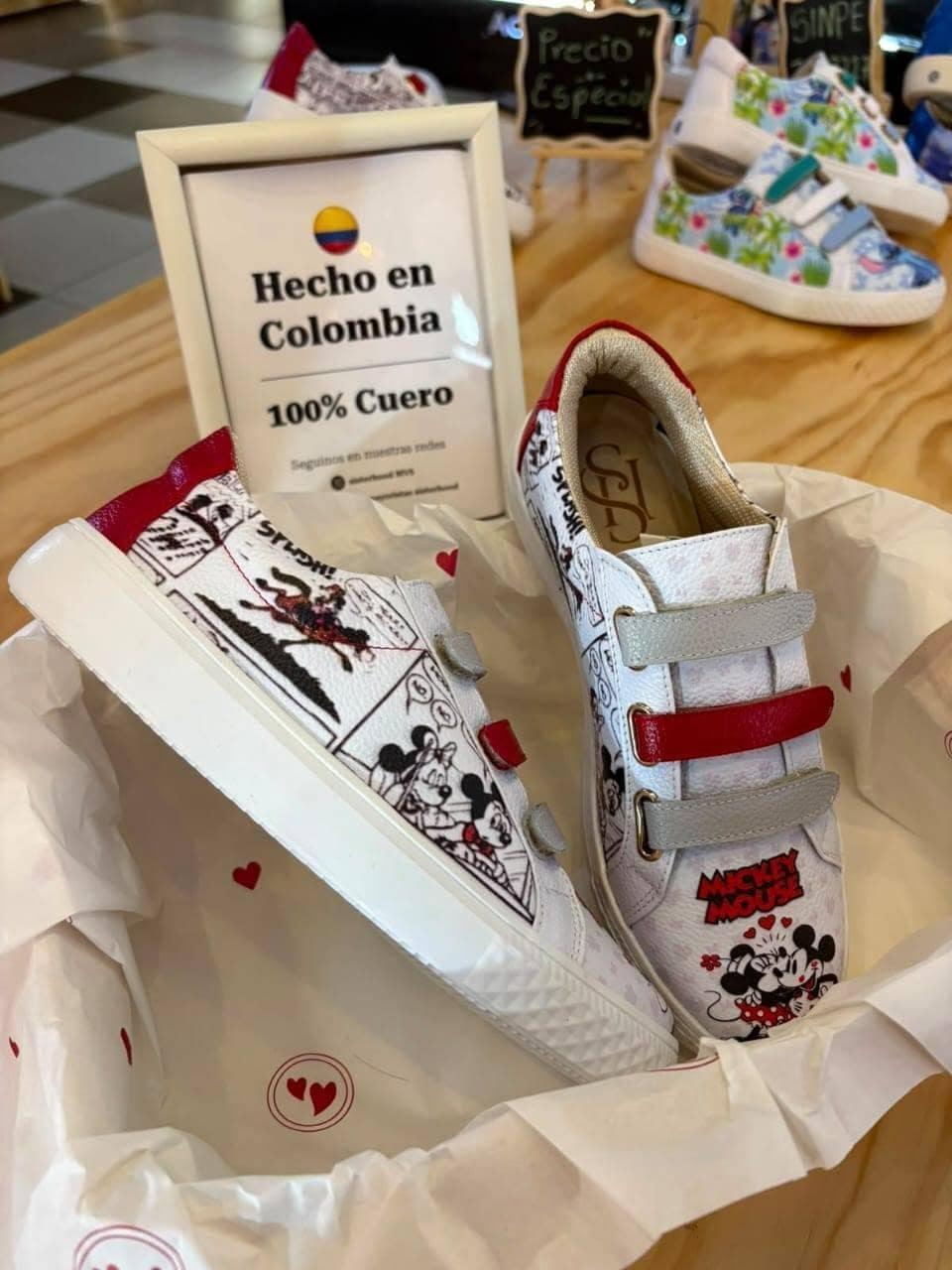 Los mismos sneakers junto al cartel de Hecho en Colombia, con el punto de venta al fondo