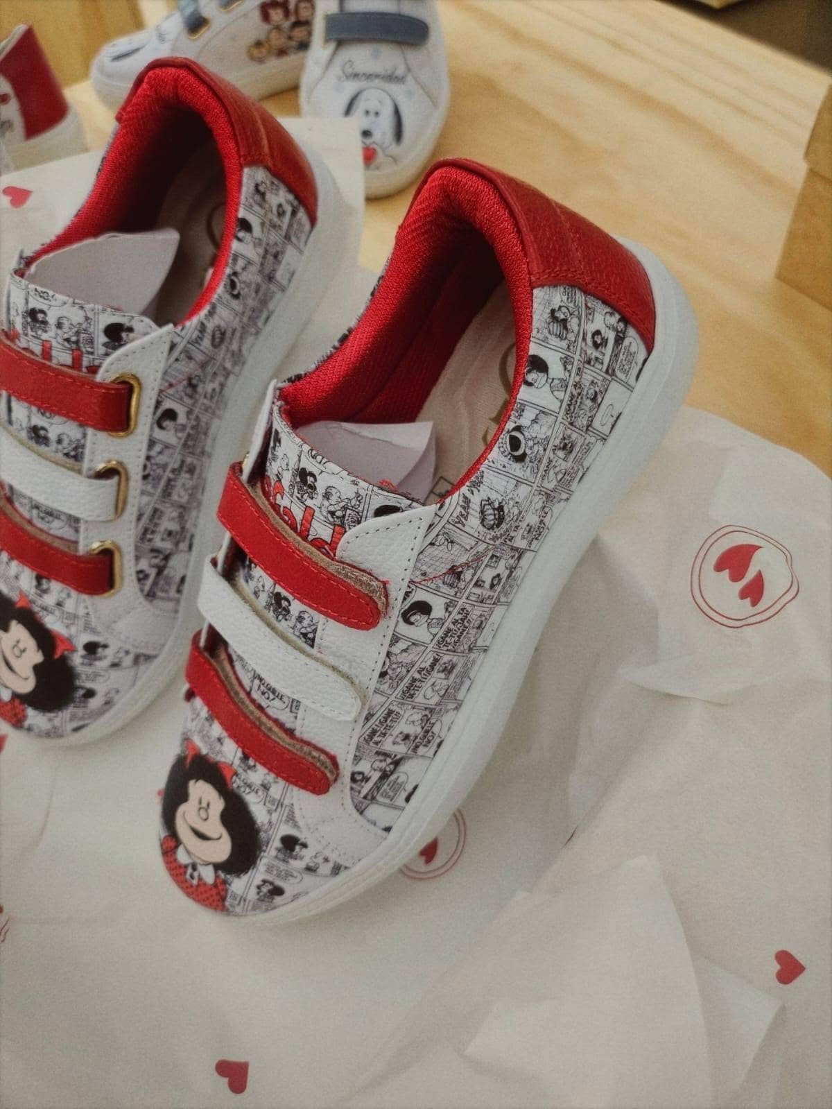Par de sneakers de cuero con tres tiras rojas y viñetas impresas en blanco y negro
