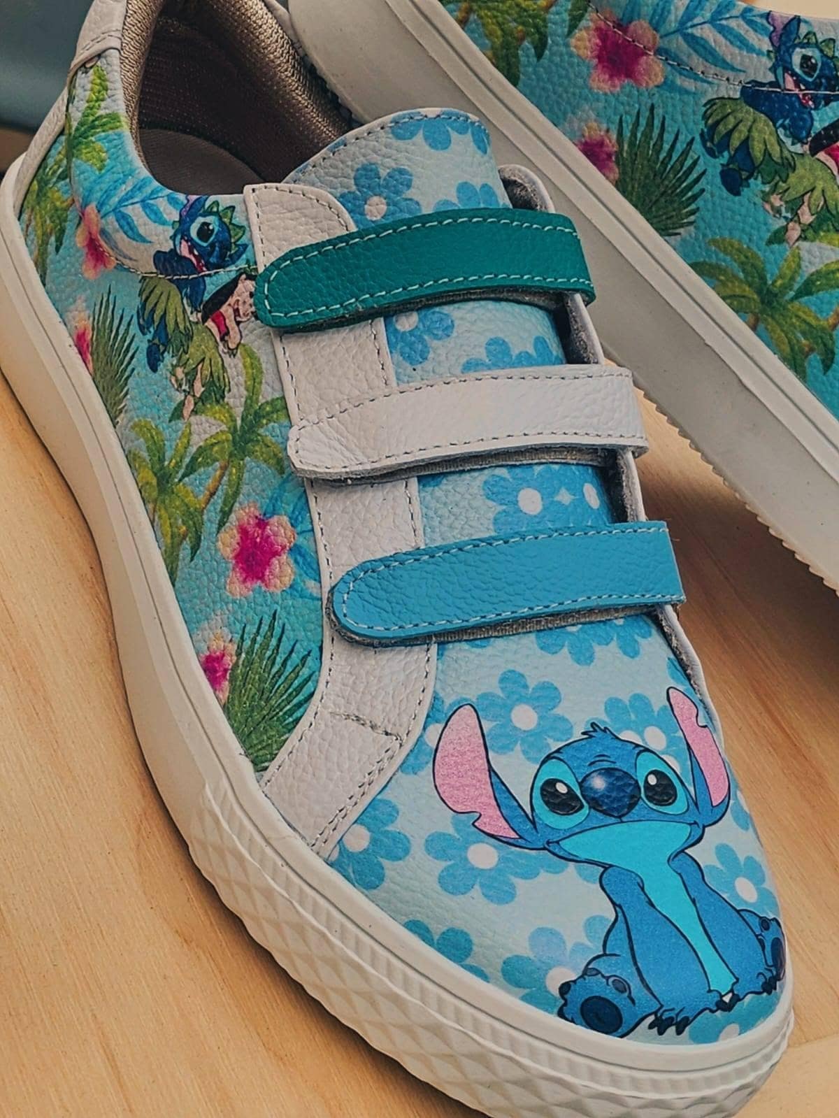 Detalle de un sneaker con estampado de follaje tropical y tira verde agua