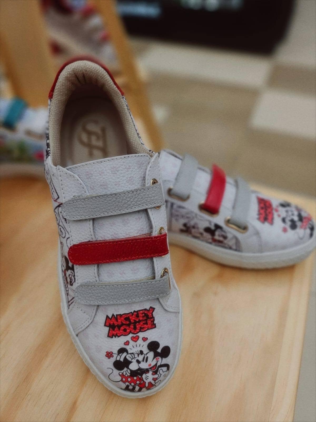 Par de sneakers de cuero con tiras gris y roja y viñetas ilustradas impresas